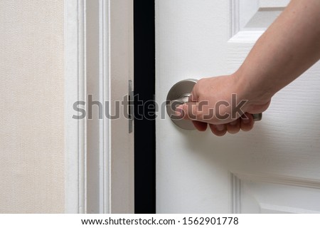 Men's hand opens and closes the door. Royalty-Free Stock Photo #1562901778