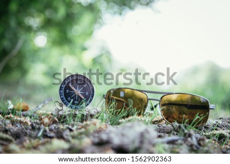 Vintage compass and sunglasses lying on the floor. Adventure and discovery concept. 