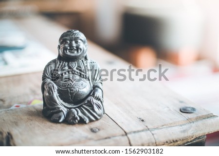 Feng shui: Buddha statue at on a table in the own living room. 