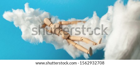 Toy man sleep on fluffy cloud. Freedom and relaxation.