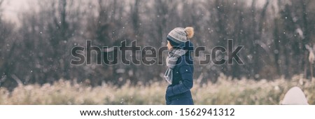 Winter snow forest walk young woman wearing cold weather coat jacket walking in outdoor nature forest relaxing banner panoramic header. Girl wearing hat, scarf, warm clothes.