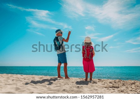 happy kids- boy and girl -travel on tropical beach