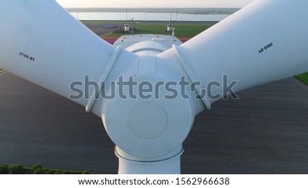 Aerial close up sundown photo of wind turbine front or alternatively referred to as a power converter is device that converts winds kinetic energy into electricity in environmentally friendly way