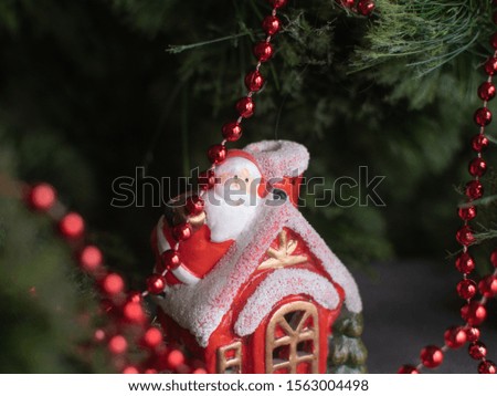 Santa Claus house on the background of a Christmas tree with colorful garlands
