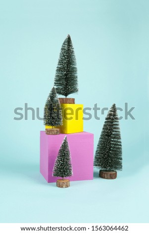 Snowy Christmas trees on a pile of coloured cubes. Play of vibrant colors. Minimal still life color photographylandscape
