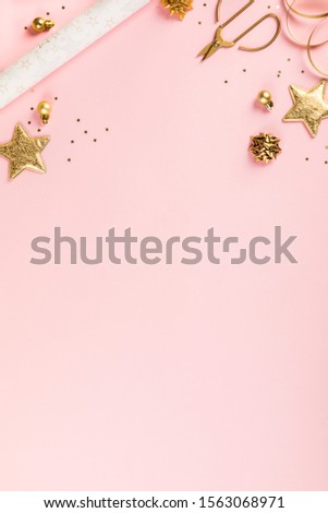 Christmas Flat Lay Background.Beautiful christmas golden shiny jewelry on a pink background.New Year composition.Holiday card.Top view, copy space.