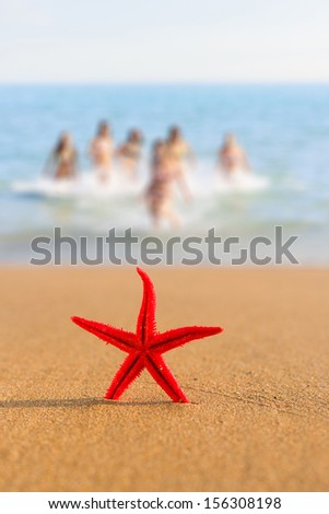 Starfish on the beach with grils running in the wter