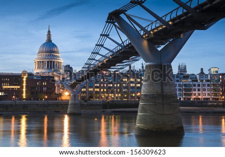 Pretty night time illuminations of St Paul's Cathedral and the millennium bridge along the river Thames.
