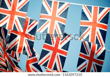 Celebratory British Union Jack flag bunting strung in rows across blue sky