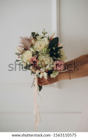 the bride’s bouquet in the bride’s hands, wedding details, selective focus, film and grain photo