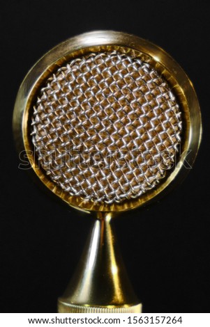Wide membrane professional microphone golden color. Texture of the metal membrane of the microphone in the recording Studio.