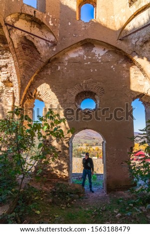 A traveler photographs the remains of the ancient Albanian church Kilwara in the village of Gilavar, built in the 17th century