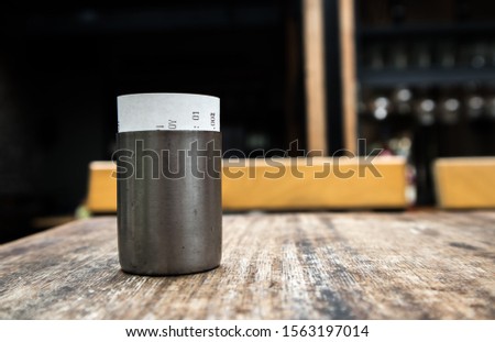 container with receipt at the cafeteria, mounted on a wooden table