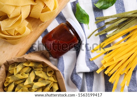 Flat lay composition with different types of pasta on fabric