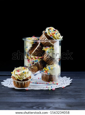 Home-made biscuit cakes. A simple cherry muffin on top. A set of muffins with dried paradise apple. Set of cakes on a tray on a black background