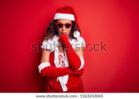 Middle age woman wearing Santa Claus costume and sunglasses over isolated red background thinking looking tired and bored with depression problems with crossed arms.