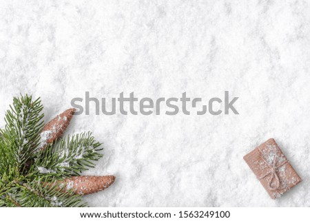 Christmas white background with snow, christmas gift and fir tree branch, flat lay, top view