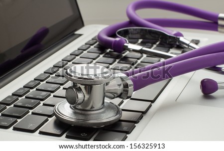 stethoscope lying on laptop keyboard