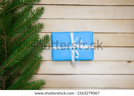 Christmas toys with fir branches on a wooden table, gift box, empty place, New Year concept. View from above.