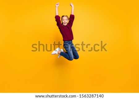 Full length body size view of nice attractive overjoyed cheerful cheery crazy pre-teen girl having fun jumping rising hands up attainment isolated on bright vivid shine vibrant yellow color background