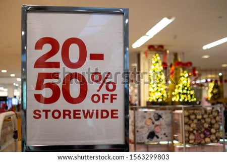 Christmas day shopping concept with a promotion sale sign and Christmas tree at the background