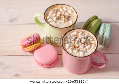 Cup of coffee and colorful macaron on white wooden background top view. Cozy breakfast. Fashion flat lay. Sweet macaroons.