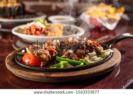 sizzling beef fajita platter in skillet Royalty-Free Stock Photo #1563333877