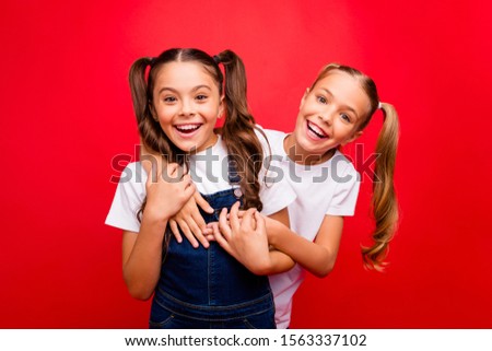 Photo of two funny pretty small ladies spending weekend time together buddies enjoy best holidays wear jeans overall white t-shirt isolated red color background