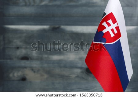 Fragment of the flag of the Slovak Republic in the foreground blurred wooden background place under the text