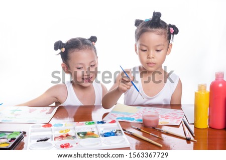 Happy children creative drawing water color photo of two little asia girl on brown wooden table. education kids people art concept. 