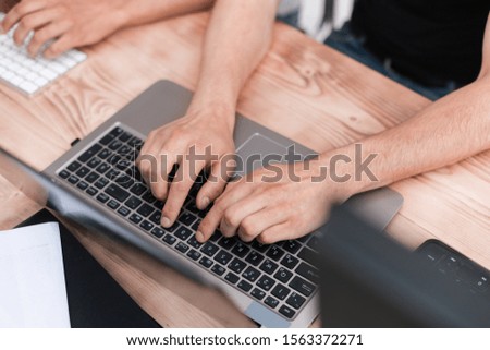 close up. guy is a student typing on a laptop