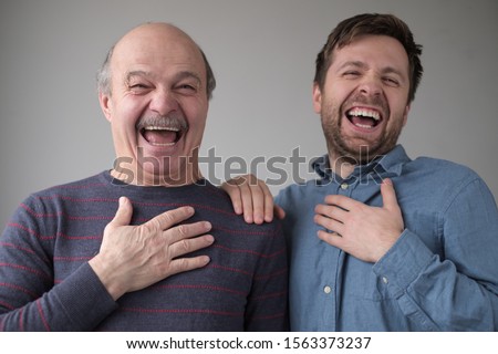 Two men and son laughing on their friend joke having a good mood. Positive facial emotion. Royalty-Free Stock Photo #1563373237