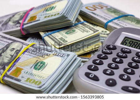 Dollar usa packs with gray calculator on white background. Money accounting and finance savings analyzing concept