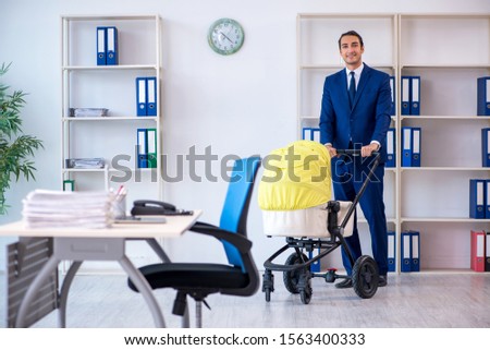 Young father looking after newborn in the office