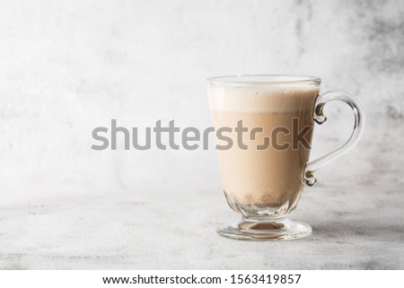 Traditional winter eggnog in glass mug with milk, rum and cinnamon and chocolate covered with whipped cream on bright marble background. Overhead view, copy space. Advertising for cafe menu. Coffee