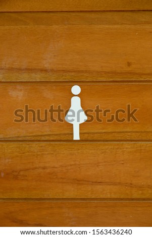 Woman symbol on wood door in restroom