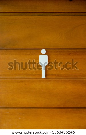 Man symbol on wood door in restroom