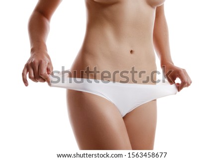 Perfect, slim, toned, young body of a girl in white underwear posing isolated on white. Plastic surgery and aesthetic cosmetology concept. Close-up.