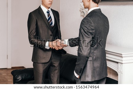 serious young businessmen shaking hands . concept of cooperation
