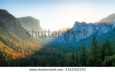 Beautiful panoramic sunrise at famous Tunnel View in scenic Yosemite Valley with El Capitan and Half Dome mountain summits in beautiful golden morning light, Yosemite National Park, California, USA Royalty-Free Stock Photo #1563502192