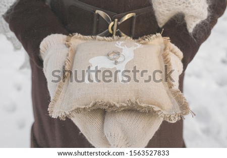 pillow for rings in the hands of a girl, in the style of a rustic with a picture of a deer