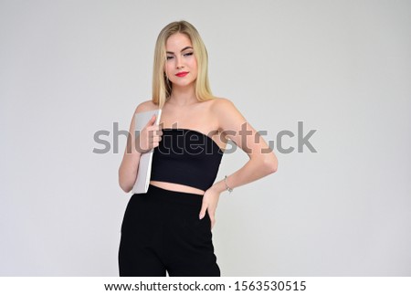 Business training concept with a girl. Portrait of a fashionable beautiful blonde model with long hair, excellent makeup, on a white background with a folder in her hands.