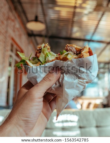 Tasty Sandwich with ham and salad in the hand