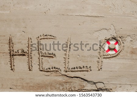 Help me the inscription and lifebuoy on the sand. Please help me. On a tropical beach.