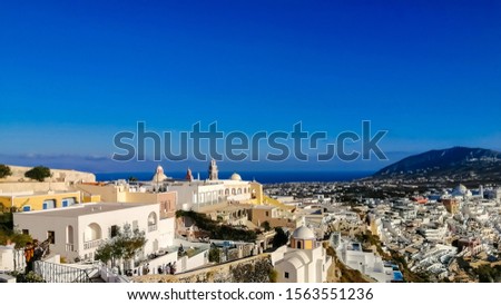 Beautiful view of picturesque village of Oia with traditional white architecture and windmills in Santorini island. Greece. Vacations background. Banner