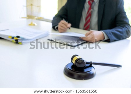 In the office of Judge or lawyer, there are balance and gavel on the table. Law firm Concept.