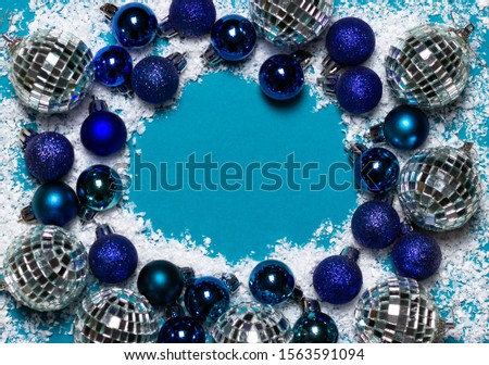 Christmas border. Christmas balls and white snow on blue background.