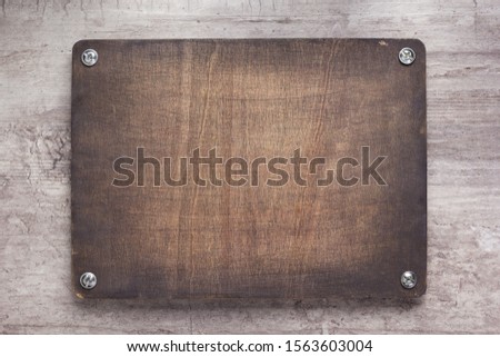 wooden nameplate or wall sign at concrete background texture surface, with screws