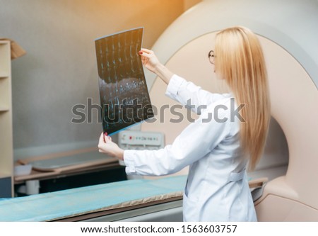 Beautiful girl doctor examine MRI picture