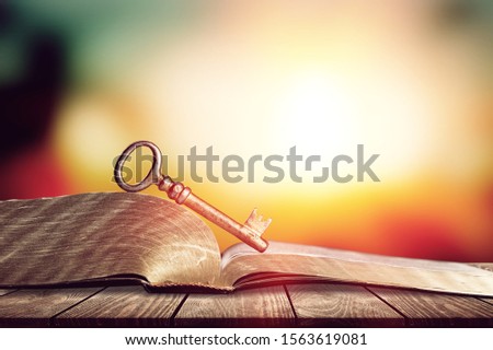 Close-up of opened book pages and glasses against vintage background